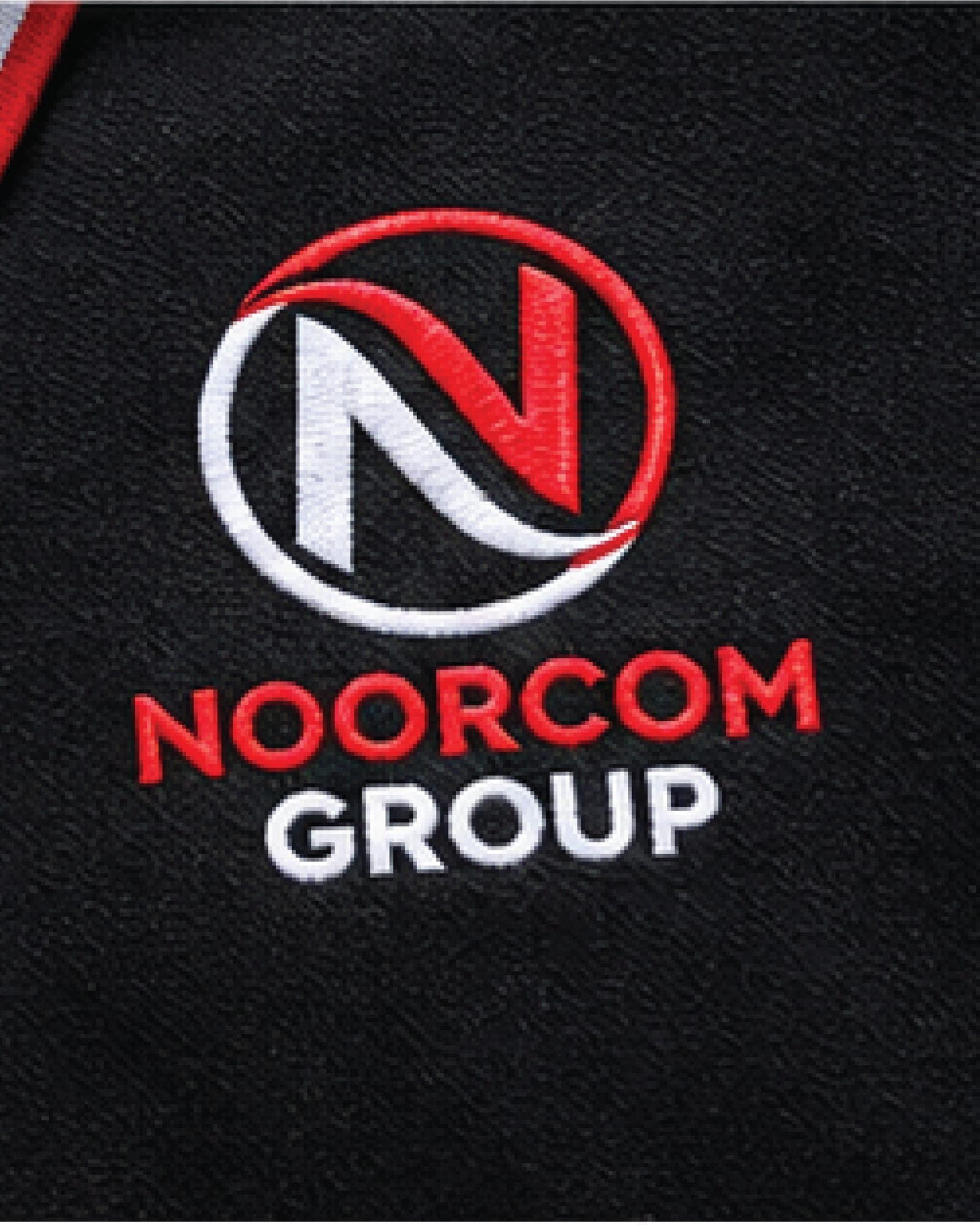 The Noorcom Group logo embroidered on a black polo shirt