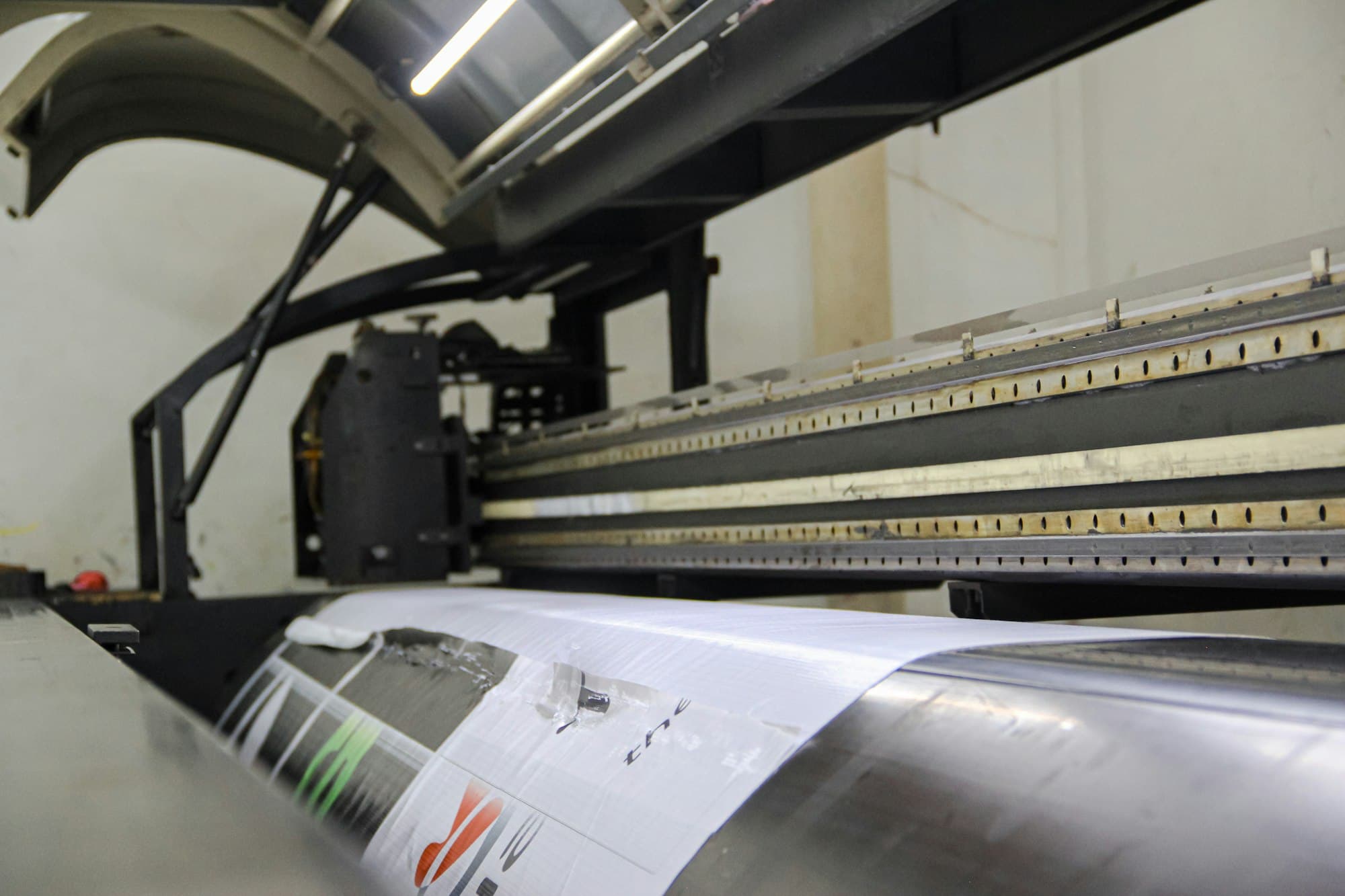 Close-up of a wide-format print head over printed vinyl