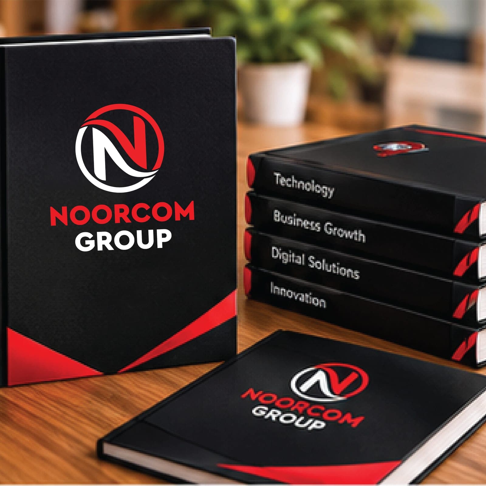 Black hardcover books with the Noorcom Group logo on the covers