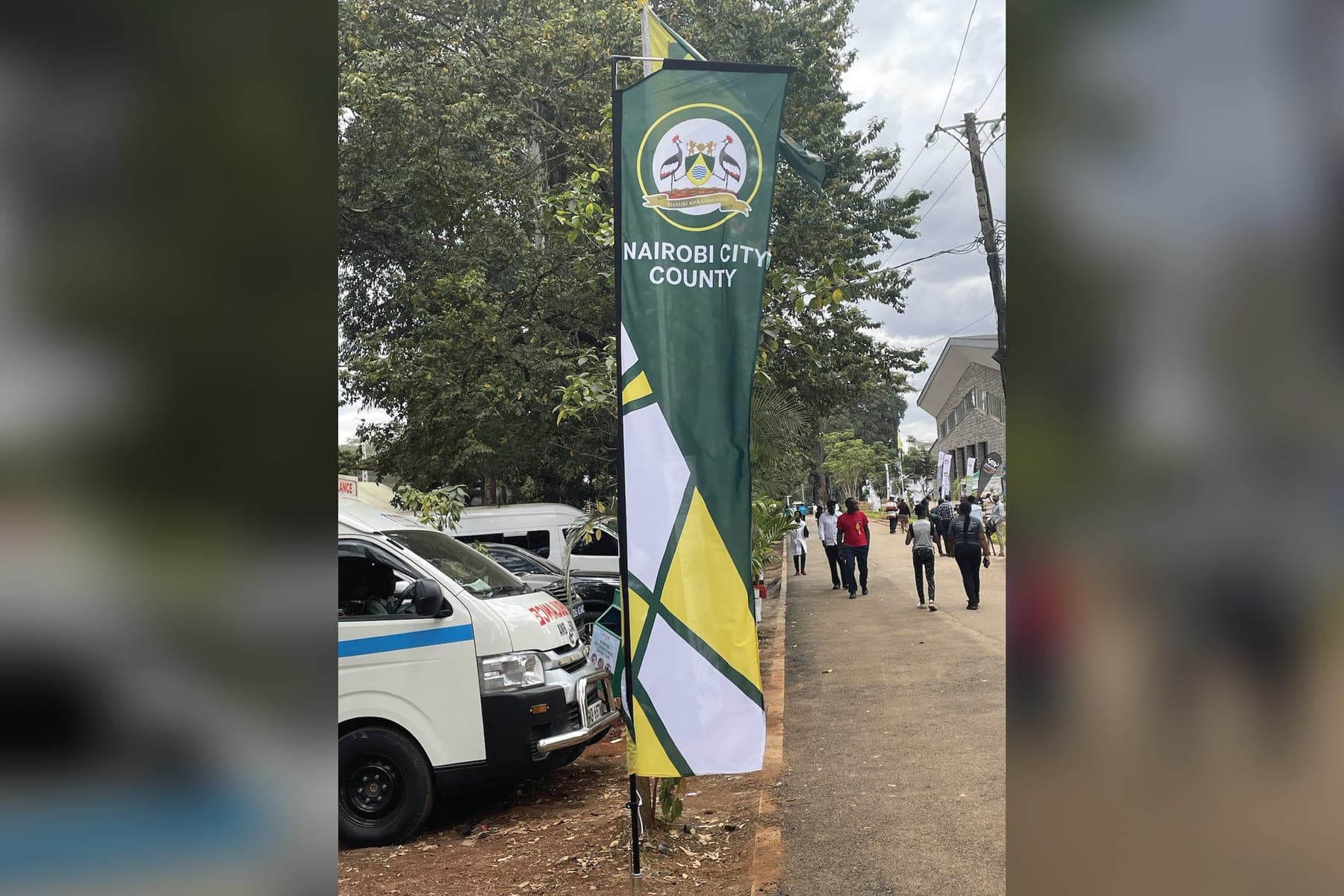 A Nairobi City County feather flag in green, yellow and white by the road into the show